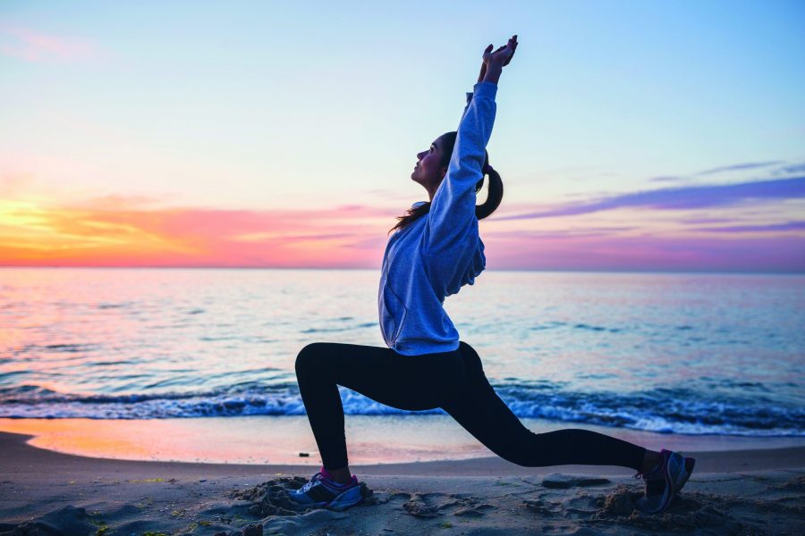 young woman doing sport exercises on sunrise beach in morning, stretching, healthy lifestyle, yoga